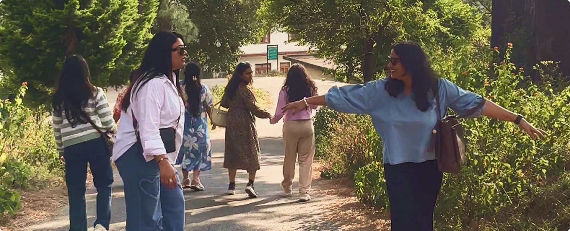 Sahelis walking hand in hand down a tree-lined path